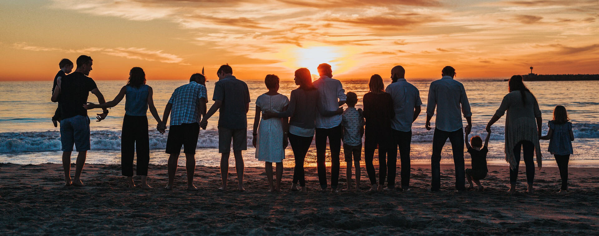 people standing on shore during golden hour